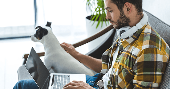 magine cu un programator dedicat ținând un laptop în brațe, alături de cel mai bun prieten al său - un câine fidel. Împreună simbolizează munca și confortul de a învăța programarea prin cursurile de la Coders Lab, chiar de acasă.